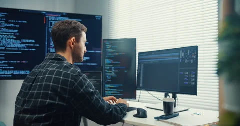 Young Caucasian male programmer writes code using computer in office. Video stock 344036073