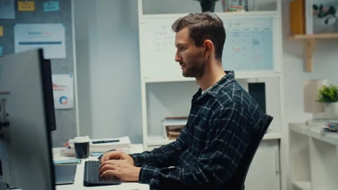 Young Caucasian male programmer writes code using computer in office. Stock Footage 344036355