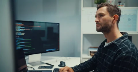 Young Caucasian male programmer writes code using computer in office. Stock Footage 344036595