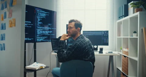Young Caucasian male programmer writes code using computer in office. Stock Footage 344036596