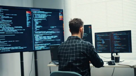 Young Caucasian male programmer writes code using computer in office. Vidéo 344037009