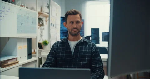 Young Caucasian male programmer writes code using computer in office. Stock Footage 344037480