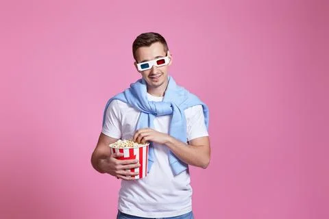 Young caucasian man in 3d glasses eating popcorn Stock Photos