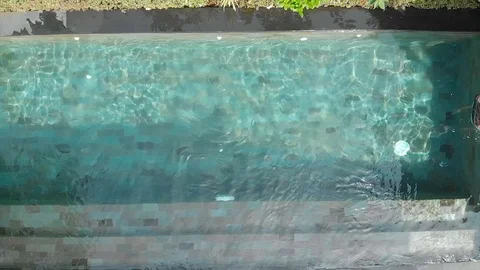 A young caucasian man in beach clothes falls into the pool. Stock Footage 103290733
