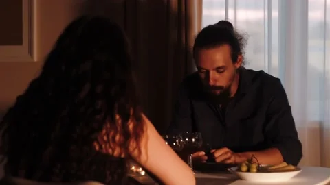 Young caucasian man with beard using hes phone on romantic dinner Stock Footage 159547536