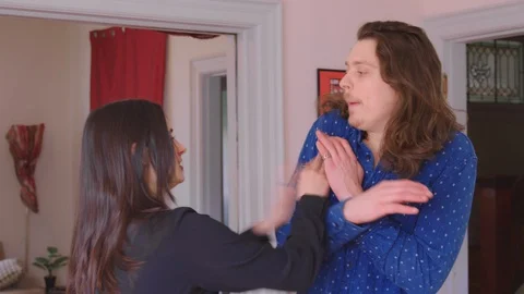 A young caucasian man being physically abused by his girlfriend Stock Footage 129337144