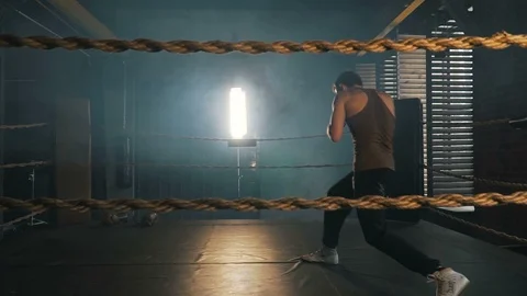 Young caucasian man boxing on the ring with yellow ropes in industrial gym Stock Footage 91586879
