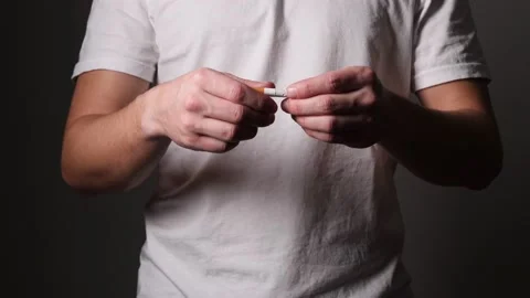 Young caucasian man breaks a cigarette in half, quit smoking concept. Stock Footage 147344199
