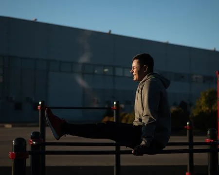 Young caucasian man doing parallel bars exercise outdoors. Stock-Fotos