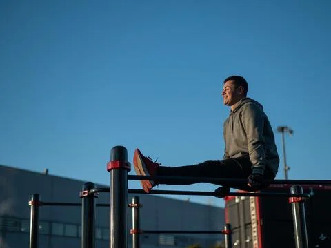 Young caucasian man doing parallel bars exercise outdoors. 스톡 사진