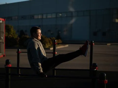 Young caucasian man doing parallel bars exercise outdoors. Foto stock