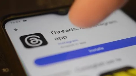 Young caucasian man download Threads by meta social network app on the phone. Stock Footage 258930735
