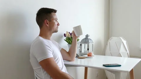 Young caucasian man drinking coffee and receiving a phone call and talking Stock Footage 135809685