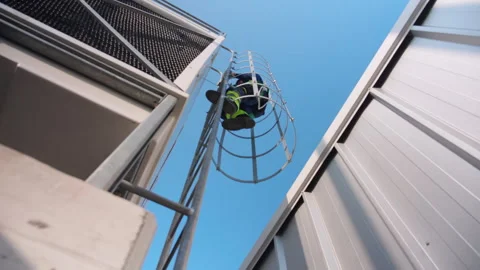Young caucasian man engineer climbing ladder on rooftop, industrial equipme.. Stock Footage 345375419