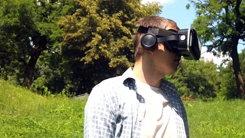 Young caucasian man exploring 3D cyber space movie with VR glasses headset in su 스톡 동영상 116795998