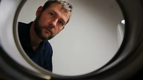 Young caucasian man loading washing machine. Man making houseworks Stock Footage 144838347