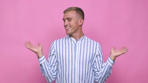 Young caucasian man makes scale with arms, feels happy and confident Stock Footage 140019740