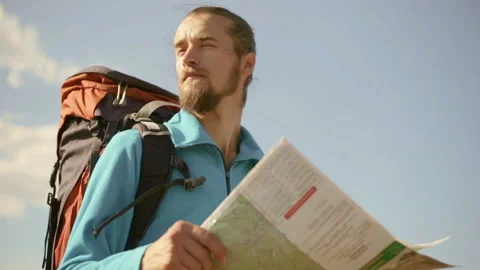 Young caucasian man with a map in his hands on a mountain trip. Stock Footage 116492929