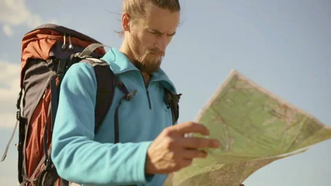 Young caucasian man with a map in his hands on a mountain trip. Stock-Footage 116493468