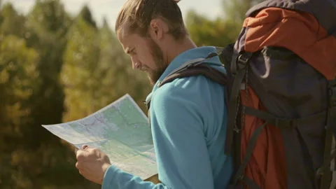 Young caucasian man with a map in his hands on a mountain trip. Stock-Footage 116498511
