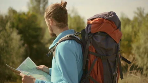 Young caucasian man with a map in his hands on a mountain trip. Stock-Footage 116498575