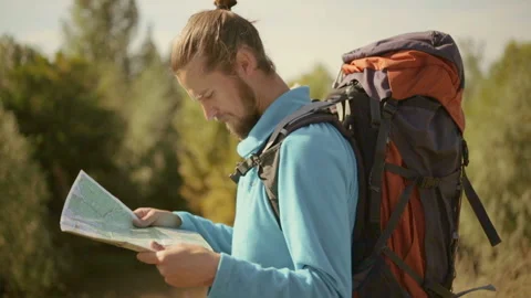 Young caucasian man with a map in his hands on a mountain trip. Stock-Footage 116498579