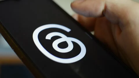 Young caucasian man open threads Meta social network app on his phone. Stock Footage 258930930