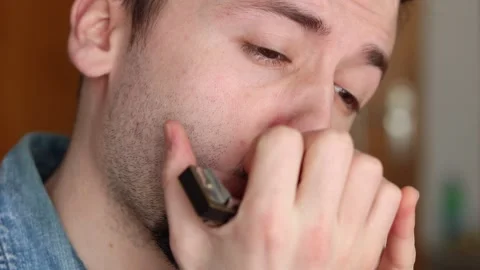 Young Caucasian Man Play Harmonica Stockbeeldmateriaal 131742640