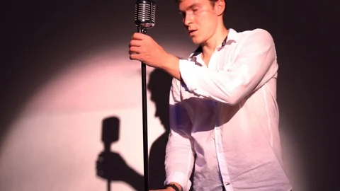 Young Caucasian man regulate and fix classic retro glare microphone on scene Stock Footage 118528838