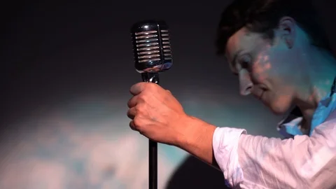 Young Caucasian man regulate and fix the classic retro glare microphone on scene Stock Footage 118528902