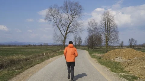 Young caucasian man is running on empty road, wearing workout clothing Stock Footage 126945030