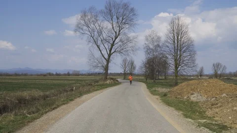 Young caucasian man is running on empty road, wearing workout clothing Stock Footage 126945248
