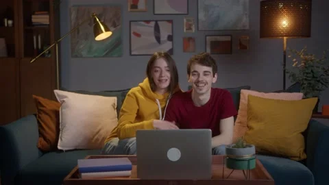 Young Caucasian man sitting at table in the living room while his beautiful wife Stock Footage 150436194
