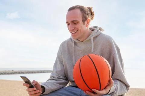 Young caucasian man smiling using his mobile phone Stock Photos