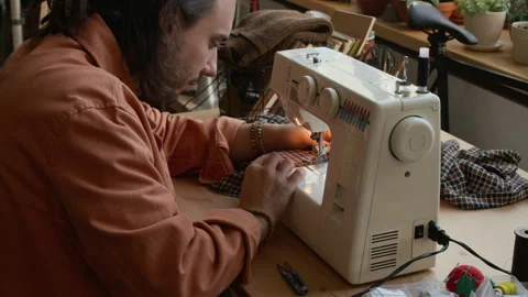 Young Caucasian Man Stitching Reclaimed Checked Fabric on Sewing Machine Stock Footage 327809266