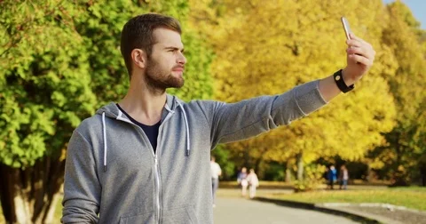 Young caucasian man taking selfies and showing his bicep on the smart phone in Stock Footage 82501081