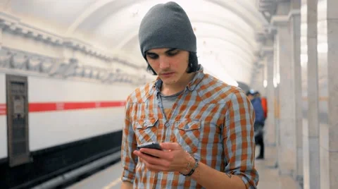 Young caucasian man talking on cellphone on subway platform Vídeos de archivo 61089656