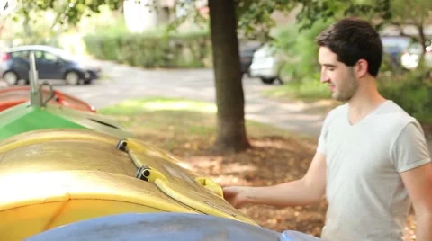 Young caucasian man throwing out plastic materials, high angled Stock Footage 41509875