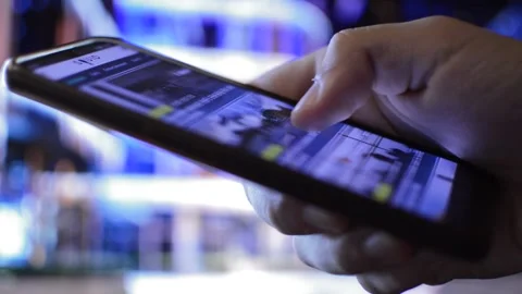 Young caucasian man using phone for reading business news in a night city Stock Footage 203714607