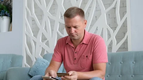 Young caucasian man using smart phone for online shopping with credit card on Stock Footage 116657856