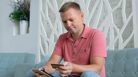 Young caucasian man using smart phone for online shopping with credit card on Vídeos de archivo 116657868