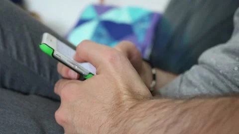 Young caucasian man using smartphone while sitting on sofa Stock Footage 162455668