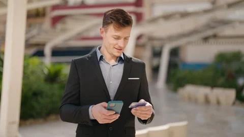 Young caucasian man using smartphone and credit card at street Video stock 171793151