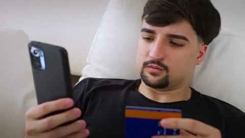 Young Caucasian man using smartphone for online shopping. Stock Footage 259900134