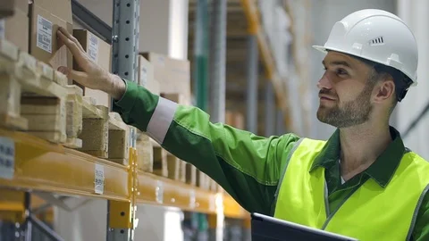 Young caucasian man using tablet computer while working at warehouse of modern Video stock 123226132