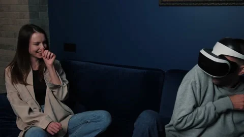Young caucasian man is using a virtual reality headset while an attractive woman Stock Footage 144136540