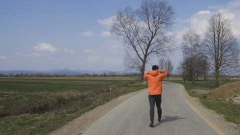 Young caucasian man is walking on empty road, wearing workout clothing Stock Footage 126945406