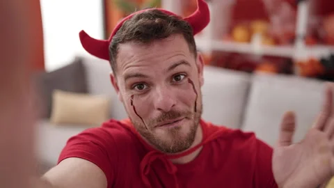 Young caucasian man wearing devil costume taking selfie picture at home Stock Footage 234155704