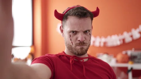 Young caucasian man wearing devil costume taking selfie picture at home Stock Footage 238608168