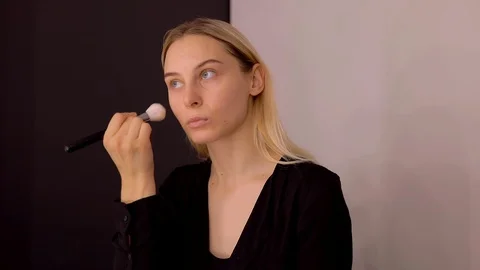 Young caucasian model applying professional makeup. beautiful woman applying Stock Footage 113808600